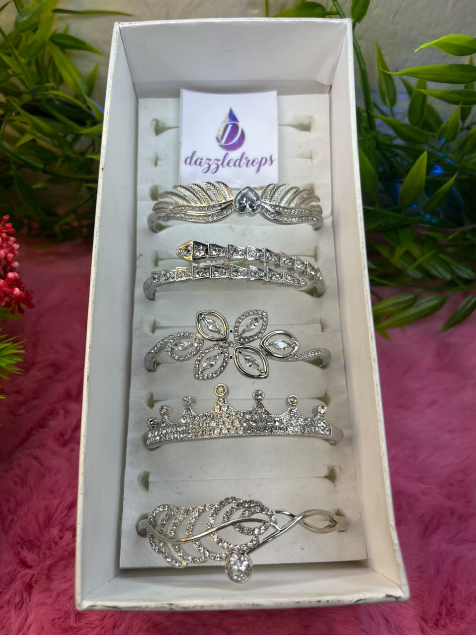 Set of silver-toned crystal cuff bracelets featuring snake, tiara, and floral designs displayed in a white DazzleDrops box. — view 3