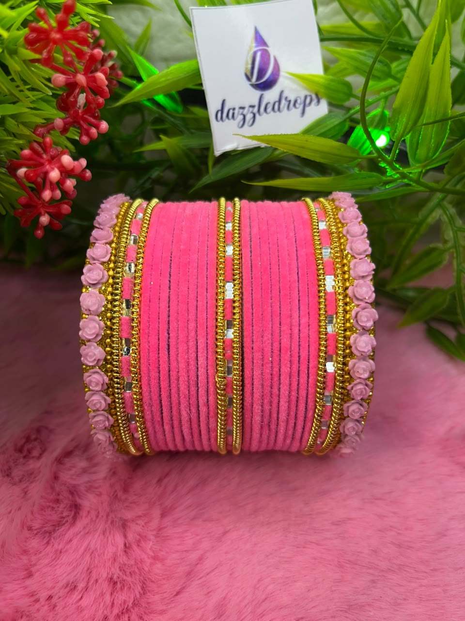 Teal green, pink, and red velvet bangle stacks with gold rose motifs and mirror work displayed on a pink background. — view 3
